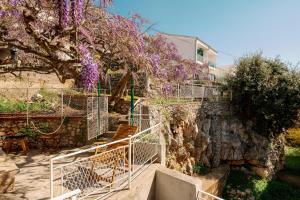 a stairway with purple wisteria hanging from a building at Piano Apartment in Šibenik