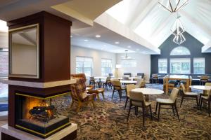 a restaurant with a fireplace and tables and chairs at Residence Inn Columbia MD in Ellicott City