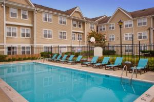 une piscine avec des chaises et un bâtiment dans l'établissement Residence Inn Columbia MD, à Ellicott City