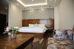 a bedroom with a bed and a table and a chair at Enso Boutique Stay in Leh