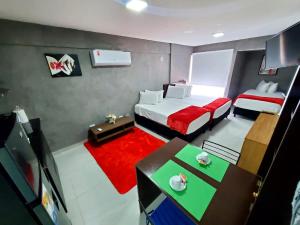 Habitación pequeña con 2 camas y alfombra roja. en Bellini Suites Apartments, en Santa Cruz de la Sierra
