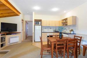 a kitchen with a table and chairs and a kitchen with a refrigerator at HAY SHED Chalet, alpine-getaways in Dinner Plain