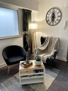 salon z krzesłem, stołem i zegarem w obiekcie Charmant Appartement Vannes Centre 30m2 w mieście Vannes