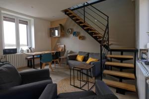 Sala de estar con escalera, sofá y mesa en La Bohème en Paissy