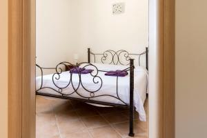 - une chambre avec un lit doté de draps blancs et d'archets violets dans l'établissement ~ Villa Demetra ~, à Noto Marina