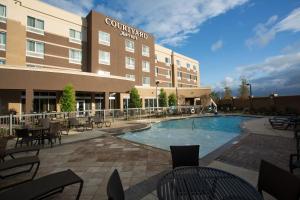 een hotel met een zwembad voor een gebouw bij Courtyard by Marriott Starkville MSU at The Mill Conference Center in Starkville