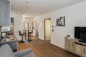 a kitchen and living room with a table and a television at Justina 7 Apartments in San Paolo
