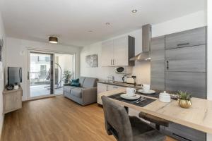 a kitchen and living room with a table and a couch at Justina 7 Apartments in San Paolo