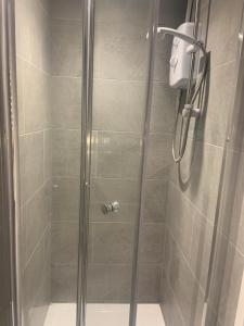 a shower stall with a glass door with a shower at Bloomsbury House - Modern studios near Anfield in Liverpool