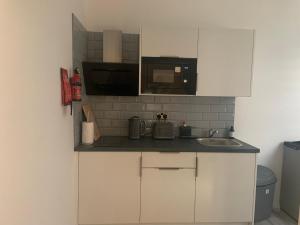 a small kitchen with a sink and a microwave at Bloomsbury House - Modern studios near Anfield in Liverpool +50 photos