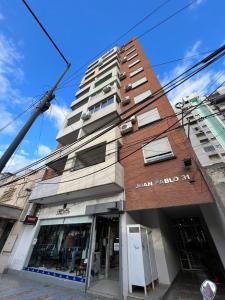 Un edificio de talla con un hombre al frente en Espectacular departamento en pleno centro en Resistencia