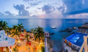 een luchtzicht op een strand met palmbomen en de oceaan bij Hotel B Cozumel in Cozumel