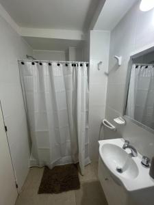 biała łazienka z prysznicem i umywalką w obiekcie Espectacular departamento en pleno centro w mieście Resistencia