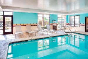 a swimming pool with chairs and tables in a building at SpringHill Suites Bakersfield in Bakersfield