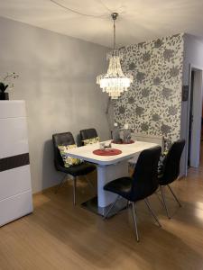 una sala da pranzo con tavolo bianco e sedie nere di Wohlfühlferienwohnung mit Terrasse in Bensberg a Bergisch Gladbach Altre 6 foto