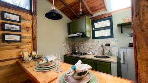 a kitchen with a wooden table with dishes on it at "Suite Cabaña Cantodeagua - Jacuzzi -Refugio en Reserva Natural Urbana - Villa de Leyva" in Villa de Leyva