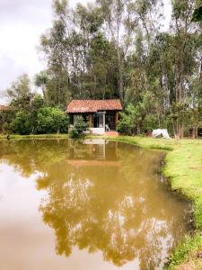 una casa en medio de un estanque en Suite Cabaña Cantodeagua-Jacuzzi, en Villa de Leyva
