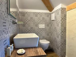een badkamer met een wit bad en een toilet bij Albola Suite Holiday Apartments in Riva del Garda
