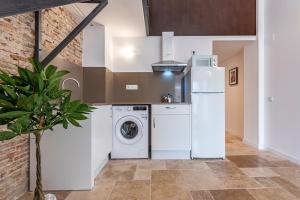a kitchen with a washing machine and a refrigerator at Atico duplex con Barbacoa y Terraza en Barri Port Maritim in Tarragona