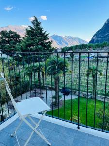 una silla blanca sentada en un balcón con vistas en Albola Suite Holiday Apartments, en Riva del Garda
