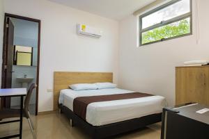 Rúm í herbergi á Genesis Hotel