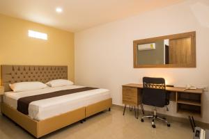 Rúm í herbergi á Genesis Hotel