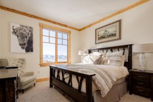 een slaapkamer met een bed, een bureau en een raam bij Modern Mountain Retreat in Victor