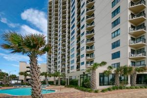 um grande edifício de apartamentos com piscina e palmeiras em The Palace Resort Unit 2310 em Myrtle Beach
