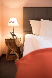 - une chambre avec un lit et une table avec une lampe dans l'établissement Ferienwohnung Steinrose, à Füssen