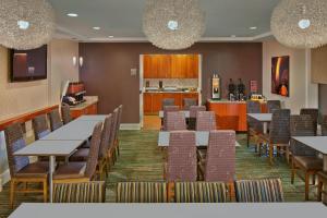 a restaurant with tables and chairs and a kitchen at Residence Inn by Marriott Waldorf in Waldorf