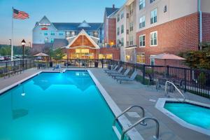 a pool at a hotel with tables and chairs at Residence Inn by Marriott Waldorf in Waldorf