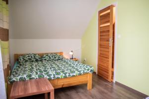 Schlafzimmer mit einem Bett und einem Holztisch in der Unterkunft Cichy Potok in Polańczyk