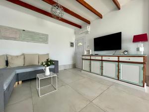 a living room with a couch and a flat screen tv at La Terraza in Playa Blanca