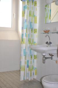 baño con lavabo y cortina de ducha en Recreatiecentrum de Kluft, en Ossenzijl