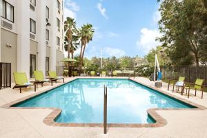 a swimming pool at a hotel with chairs around it at Springhill Suites by Marriott West Palm Beach I-95 in West Palm Beach