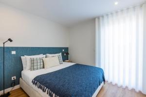ポルトにあるPestana Apartments - Premiumのベッドルーム1室(大型ベッド1台、青い毛布付)