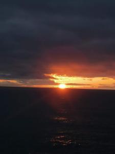 a sunset over the ocean with the sun in the sky at Piso en Muxía con magníficas vistas al mar in Muxia