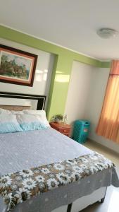 a bedroom with a bed and a painting on the wall at Renacer apartamentos in Tacna