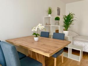 a dining room with a wooden table and blue chairs at 55m2 Modern Flat with Balcony in Vienna