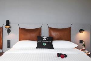 a bed with a black and white pillow on it at Moxy Cologne Bonn Airport in Cologne