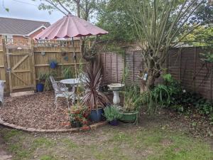 a backyard with a table and an umbrella and plants at Henley Town Rooms in Henley on Thames