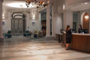 Eine Frau steht an der Rezeption in einer Hotellobby. in der Unterkunft Paris Marriott Opera Ambassador Hotel in Paris