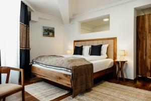 a bedroom with a bed with a wooden headboard at Edemus - Motel & Restaurant in Maglaj