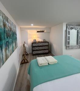 リスボンにあるCasinha dos Remédiosのベッドルーム1室(ベッド1台、タオル2枚付)