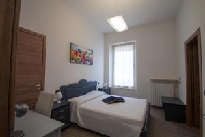 カプリーノ・ヴェロネーゼにあるPalazzo di Primavera Guest Houseのベッドルーム1室(ベッド1台、テーブル、窓付)