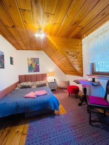 a bedroom with a bed and a wooden ceiling at Siedlisko Zatoka in Augustów