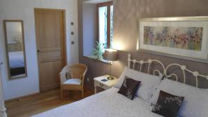 a bedroom with a bed and a table and a chair at Villas de Leypinas B&B in Saint-Pardoux-Corbier