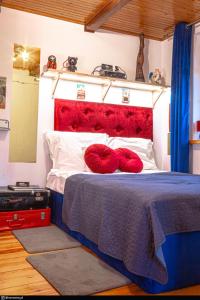 Schlafzimmer mit einem Bett mit rotem Kopfteil und roten Kissen in der Unterkunft Retro Haven - A Timeless Escape for Nostalgic Souls by NamastayPL in Marki
