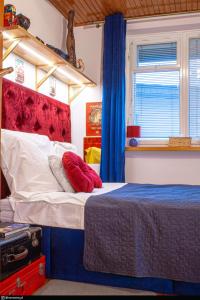 Schlafzimmer mit einem Bett mit rotem Kopfteil in der Unterkunft Retro Haven - A Timeless Escape for Nostalgic Souls by NamastayPL in Marki
