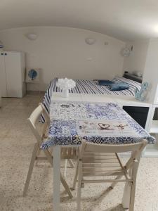 a table and a bed in a room at La tavernetta del Peo casa vacanze in Sanremo